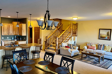 a living room with a staircase and a dining table