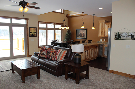 a living room with a leather couch and a kitchen